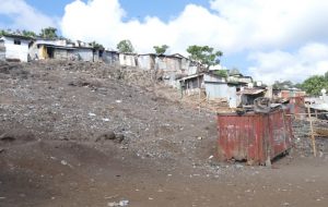 Le container-salon parmi les déchets et les cases à Mangatélé-Kawéni