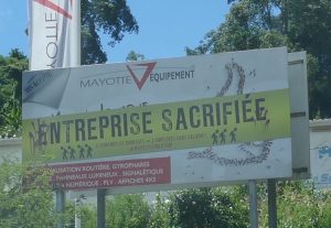 Cri de détresse sur une pancarte : "Mayotte équipement : 6 semaines de barrages, 7 employés sans salaire"
