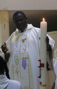 Le père Bienvenu apporte la lumière de Pâques dans l'église Notre Dame de Fatima 